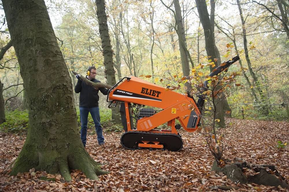 man using a wood chipper in the woods