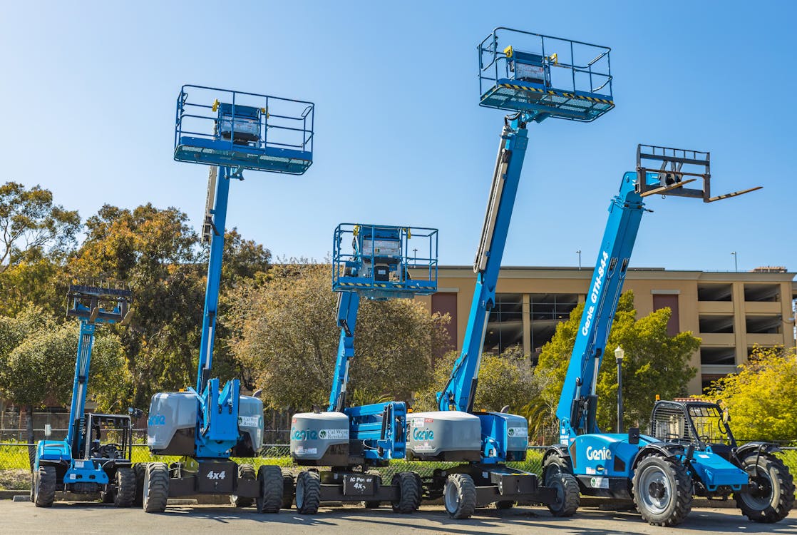 five genie boom lifts in a parking lot